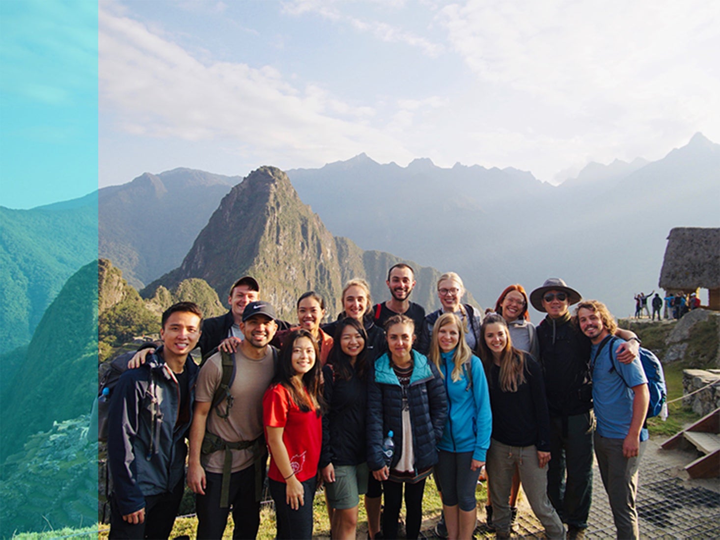 A group of study abroad students pose in front of a mountainous backdrop.