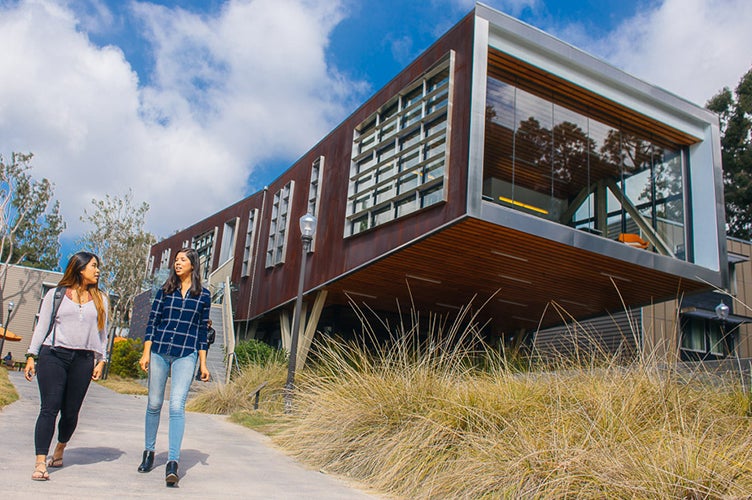 Two students walk past Saxon Suites.