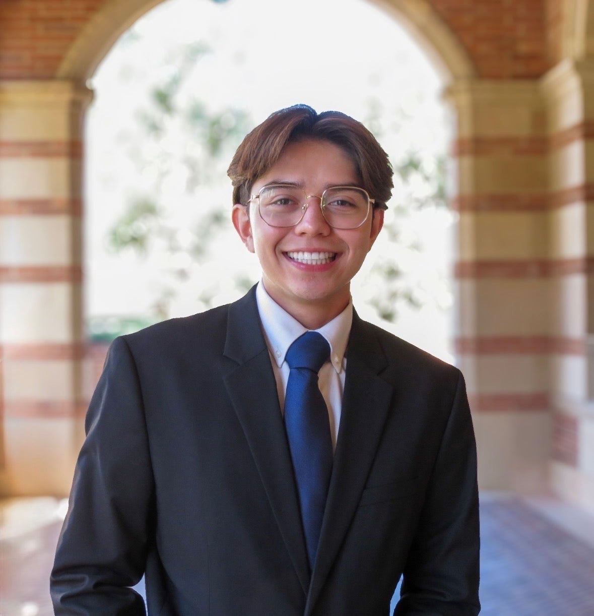 Portrait of Nicholas Armendariz standing in front of a garden