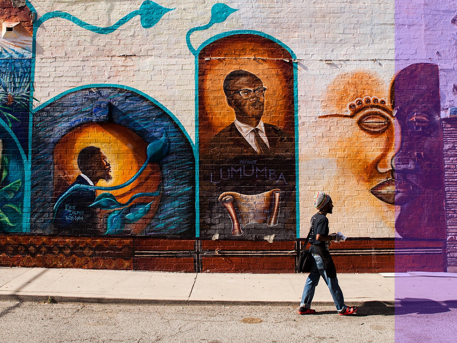 A woman walks by a large mural in the Liemert Park Village section of L.A.