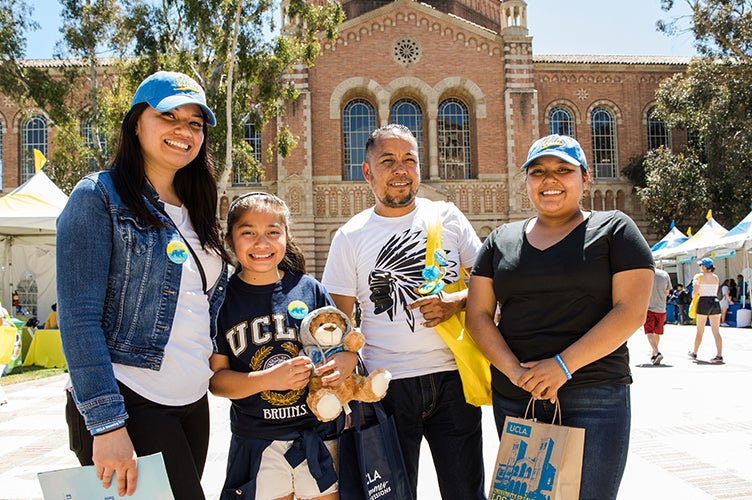 A student smiles with her family during Bruin Day.