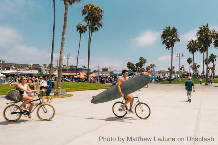 People bike and walk near the beach in Santa Monica.