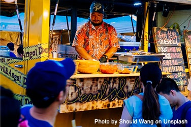 Customers wait for their order at a food stand.