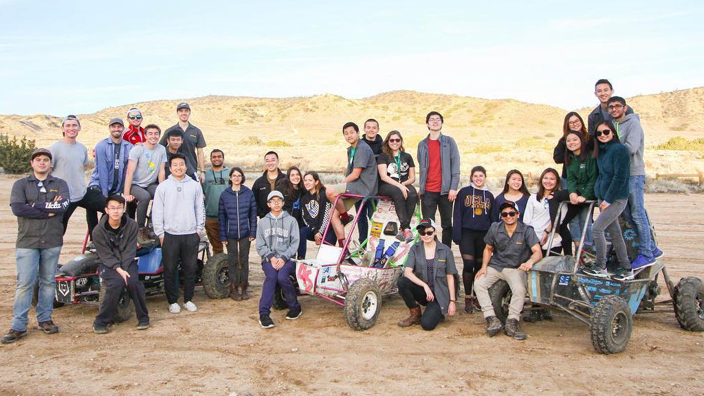 The Bruin Racing Baja SAE team poses with some off-road vehicles.