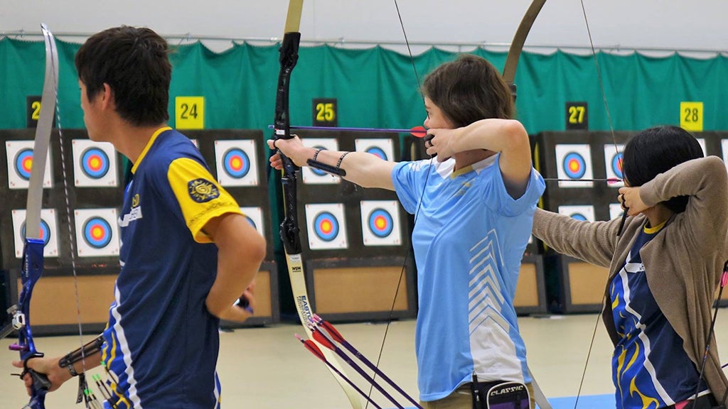 UCLA Archery members aim their bows and arrows at the bullseye. 