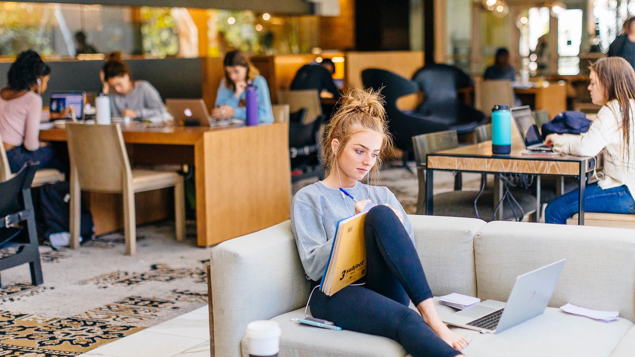 A student works on her laptop at a table by the window in the Study at Hedrick.